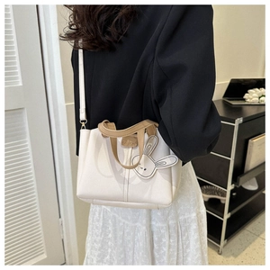Détail du sac cabas blanc crème avec poignées marron contrastées et charm lapin mignon