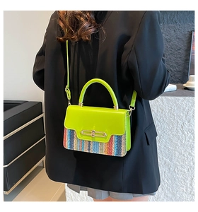 Neon green contrast straw handbag shown on model wearing a chic black blazer