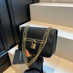 Minimalist black crossbody bag with faux crocodile texture and gold chain strap