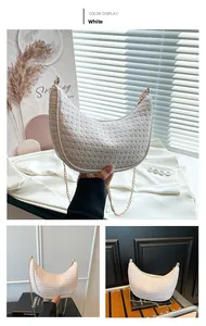 Detail of white woven crescent bag with gold chain and checkerboard texture