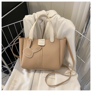 Vue détaillée du sac cabas beige avec poignées blanches et breloque lapin en cuir adorable