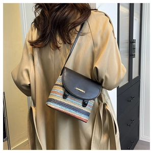 Detail of rainbow straw woven bucket bag with black leather flap and gold JINPIN logo