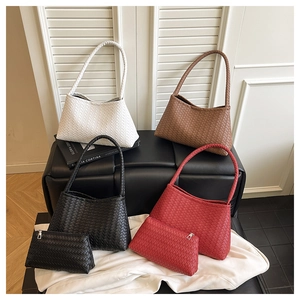 Detailed view of woven shoulder bag set in white brown black and red tones