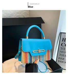 Detail of blue leather flap and colorful woven straw body with gold metallic buckle