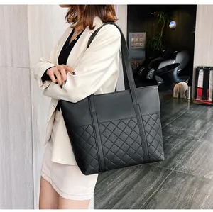 Vue latérale du grand sac cabas noir avec motif matelassé classique et cuir grainé lychee