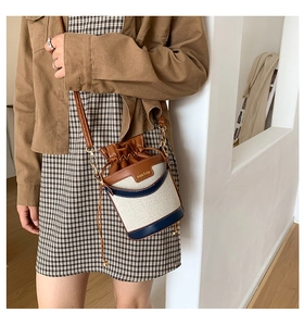 Detail of retro bucket bag in canvas and faux leather with adjustable drawstring on shoulder
