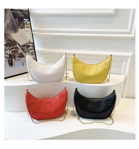 Detailed view of woven crescent shoulder bags in four colors with gold chain straps