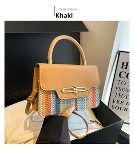 Detail of khaki leather handle and colorful woven pattern on a stylish crossbody bag