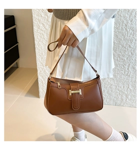 Detailansicht der braunen Schultertasche mit eleganter goldener Metallschnalle am Verschluss
