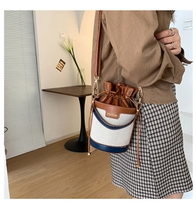 Detail of vintage bucket bag featuring canvas and blue leather contrast with drawstring