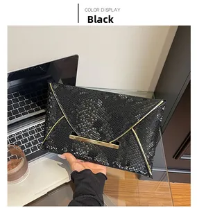 Détail de la pochette enveloppe noire motif serpent avec bordure en métal doré