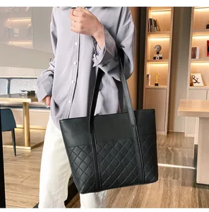 Détail du cabas noir en cuir grainé avec des coutures en losanges matelassées chic