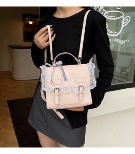 Detail of light pink PU leather bag with white lace trim and bow ribbon decorations