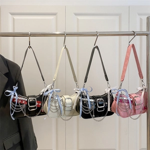 Y2K chain shoulder bag with stars and bow charms in black, cream, and pink colors