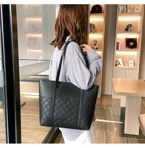 Détail d'un sac cabas en cuir matelassé noir pour femme montrant la texture et la bandoulière