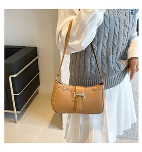 Detailansicht einer Vintage-Halbmond-Tasche in Camel mit Metallschnalle an einem Modell