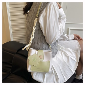 Détail du sac bandoulière blanc et vert avec bandoulière en soie et fleur