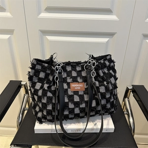 Chic black and white checkered tweed tote bag with leather tag and chain strap details