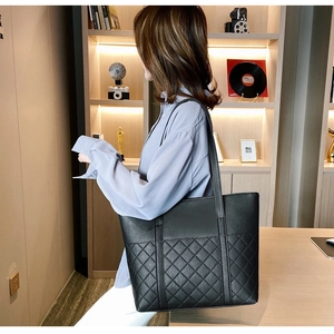 Détail du sac cabas noir avec motif matelassé en losange classique et design spacieux