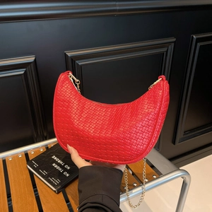 Red woven leather crescent underarm bag with gold chain strap in minimalist style