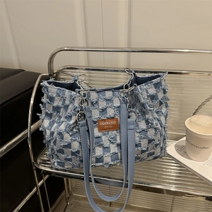 Chic blue and white checkerboard denim tote bag with distressed frayed edges and chain strap