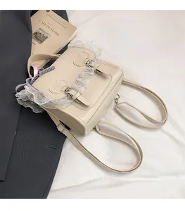 Detail of cream lace trim backpack with double bow buckles on a vintage background