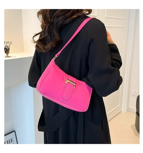 Detail der trendigen rosa Unterarmtasche mit Goldschnalle an einem Model im Minimal-Stil