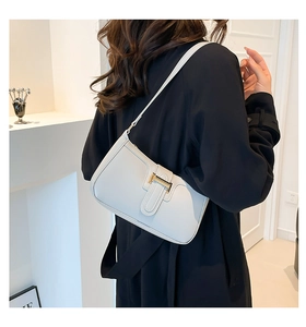 Detail der cremefarbenen Crescent Bag aus Kunstleder mit goldener Metallschnalle