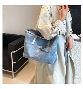 Dettaglio della borsa tote azzurra con motivo marmorizzato e logo argento metallizzato