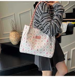 Vue détaillée du sac cabas blanc avec motifs fleurs et ours et anses tressées roses