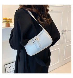 Detail der hellblauen Leder-Baguette-Tasche mit Metallschnalle getragen am schwarzen Top