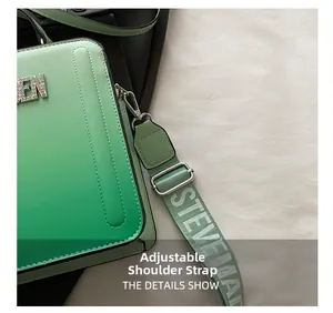 Detail shot of the adjustable wide fabric strap and silver metal hooks on a green handbag
