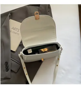Detail view of white semi-circle shoulder bag showing inner space and golden hardware