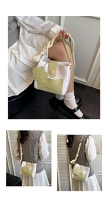 Détail du sac seau bandoulière avec boucle en bois, poignée tressée et fleur