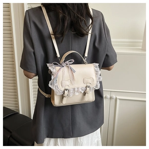 Detail of cream school backpack featuring white lace trim and blue checkered bow decor