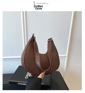 Detail of coffee brown hobo bag with pebbled leather texture and gold hardware details