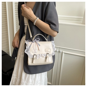 Detail of cream white PU leather bag featuring elegant lace trim and ribbon bow accents