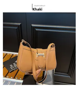 Detail der khakifarbenen Leder-Schultertasche mit silberner Metallschnalle in schicker Handansicht
