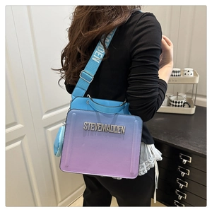 Detail of blue to purple gradient crossbody bag with wide logo strap worn by a model