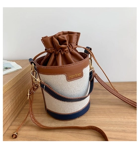 Detail of retro color-block bucket bag with canvas texture and leather drawstring