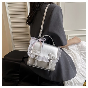Detail of silver backpack with lace trim and pink plaid bow for a sweet academic look
