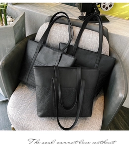 Détails de cabas noirs avec gaufrage rose et textures tissées sur un canapé gris