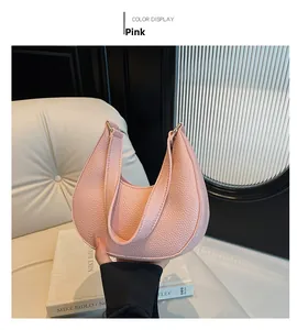 Detailed view of pink crescent bag with lychee grain texture and metal hardware