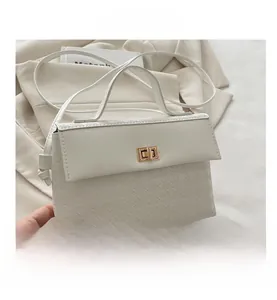 Detail of white houndstooth texture handbag featuring elegant golden rectangular twist lock