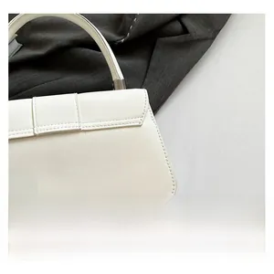 Detail shot of the premium white synthetic leather texture and silver metal hardware of the bag
