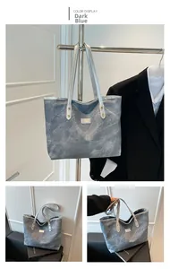 Dettaglio della borsa tote blu navy testurizzata con manici argento e etichetta