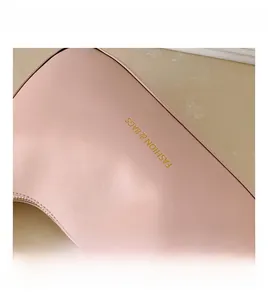 Close-up of pink leather handbag showing fine texture and gold letter printing