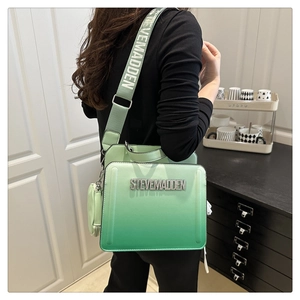 Detail of green gradient crossbody bag with wide shoulder strap and small pouch accessory
