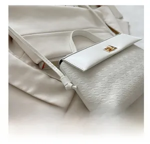 Detail of white houndstooth embossed texture on a handbag with golden twist lock