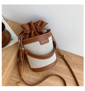 Close-up of contrast color bucket bag with drawstring closure and brand logo detail